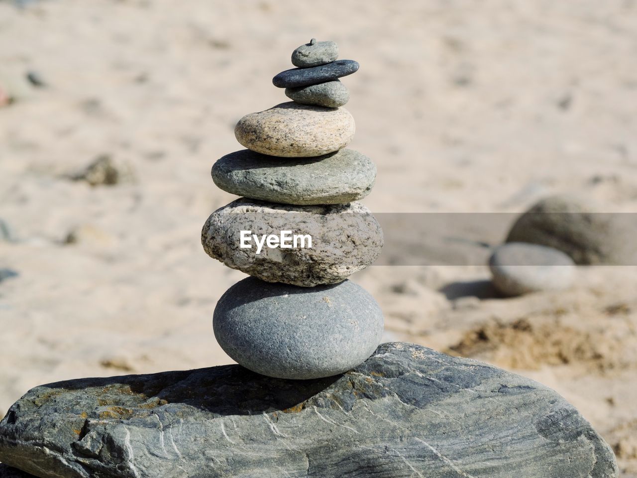 CLOSE-UP OF STONE STACK ON ROCK AT BEACH