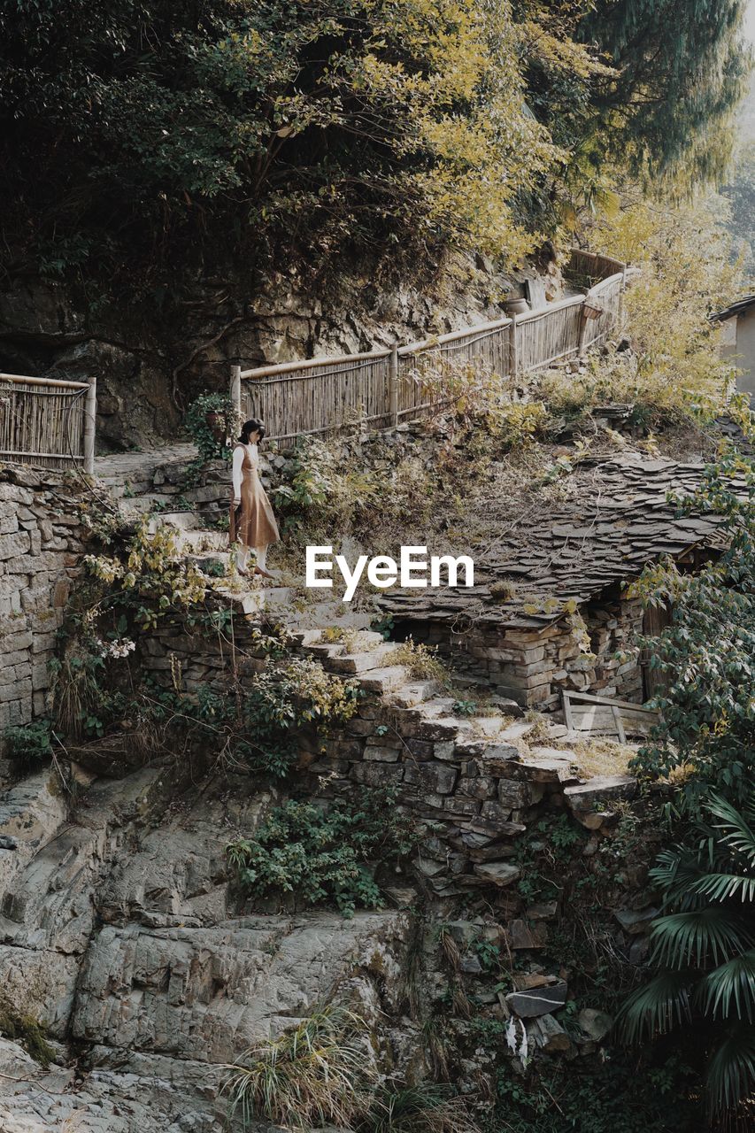 Woman walking on staircase in forest