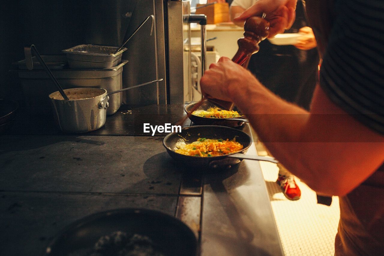 Midsection of man preparing food in kitchen