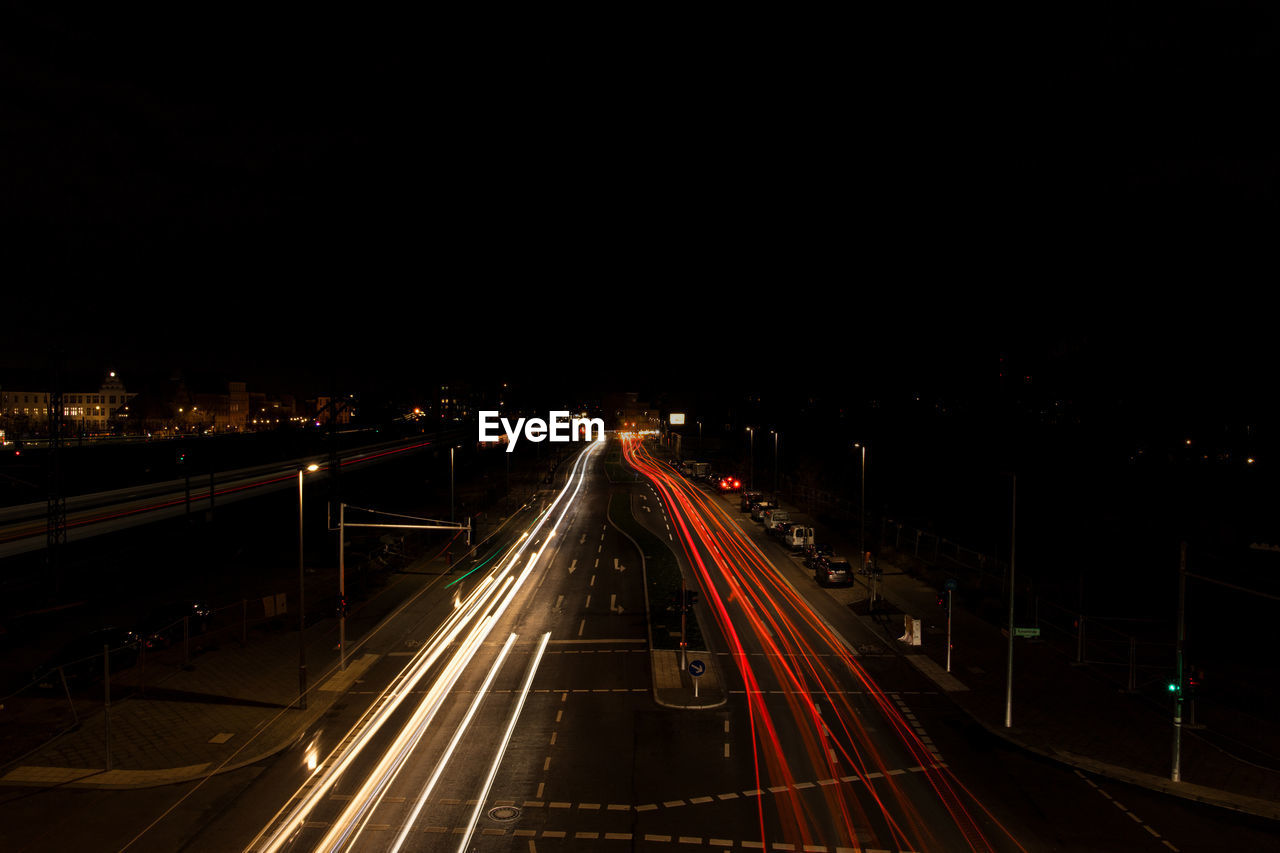 High angle view of light trails on road against clear sky at night