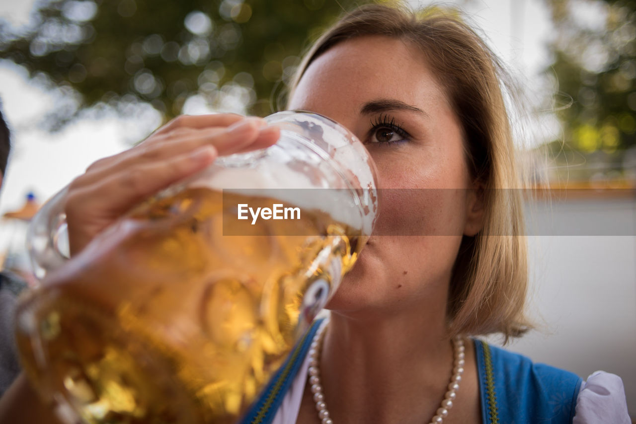 Close-up of woman drinking drink outdoors