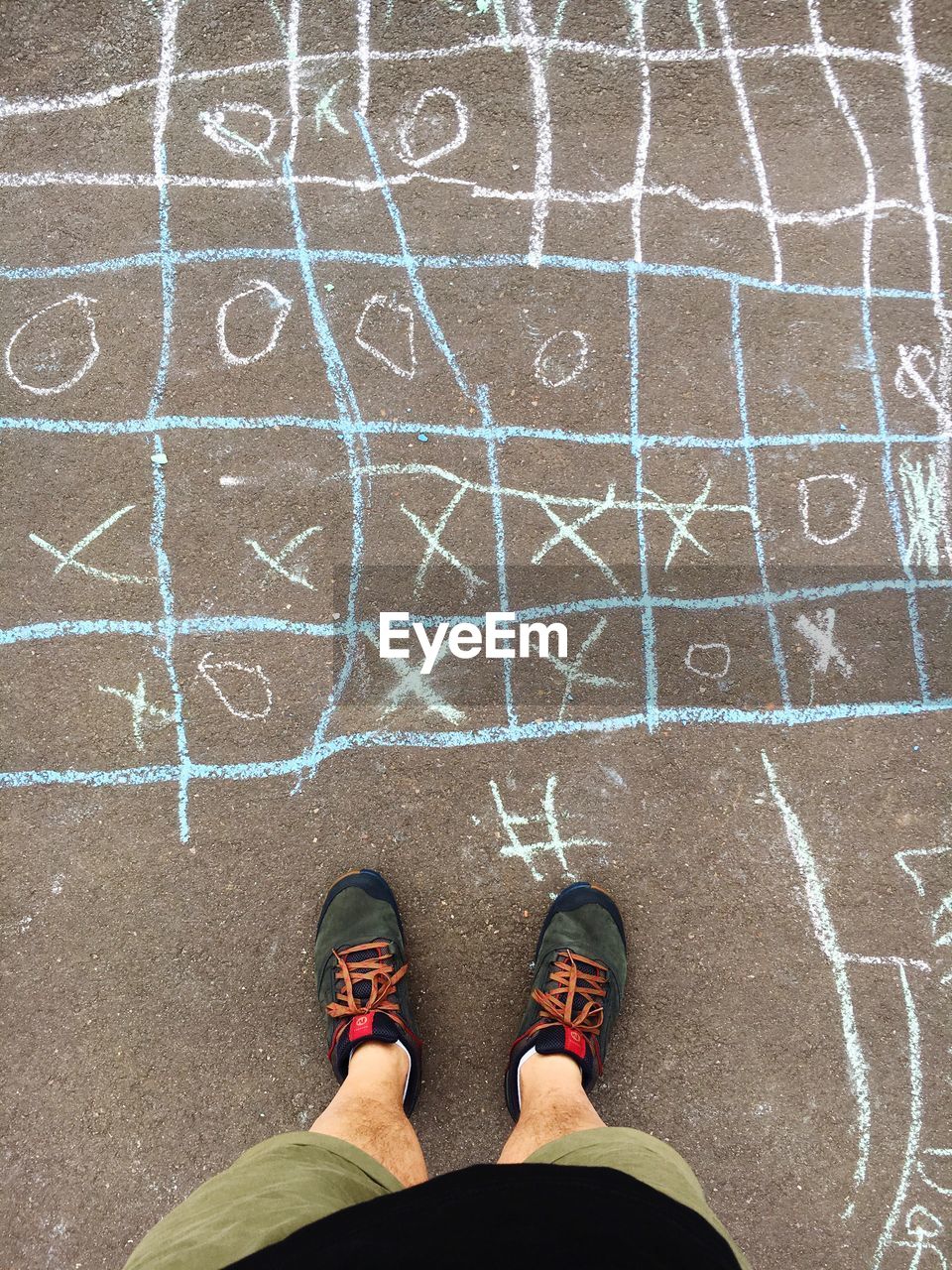 Low section of boy standing by chalk art on street