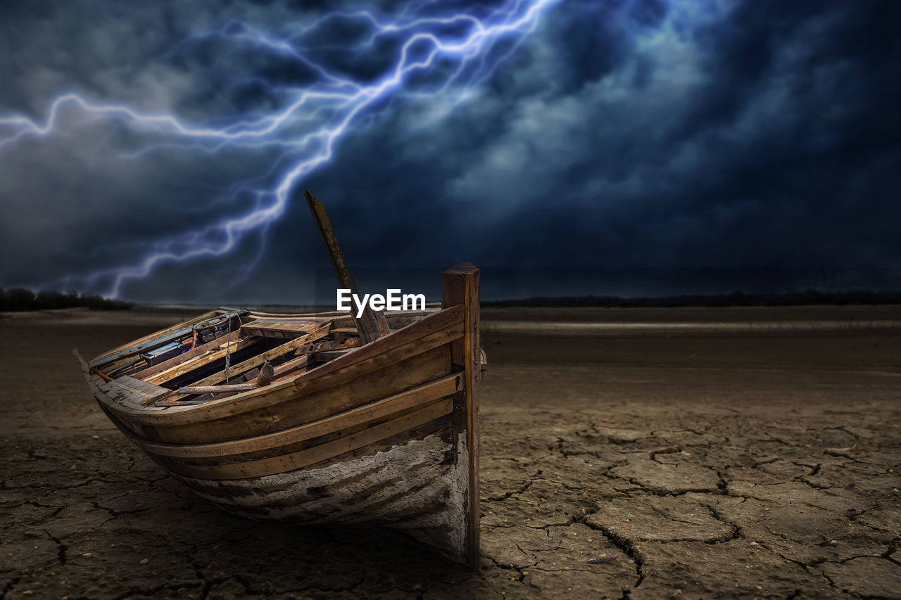 ABANDONED BOAT ON SHORE AGAINST SKY