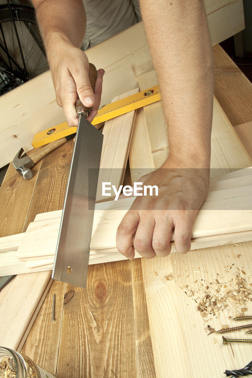 Close-up of carpenter cutting wood