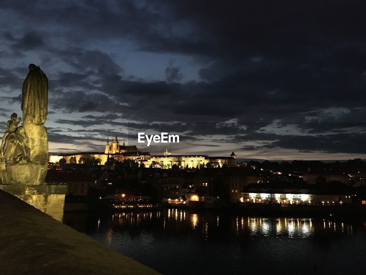 VIEW OF ILLUMINATED BUILDINGS AGAINST CLOUDY SKY