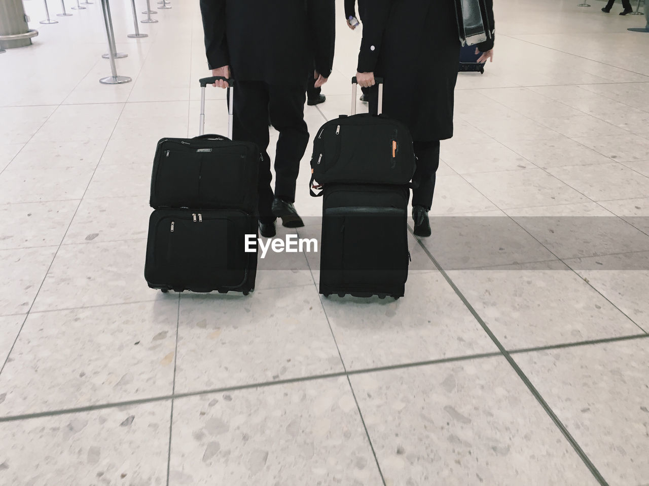 Low section of people carrying luggage at airport