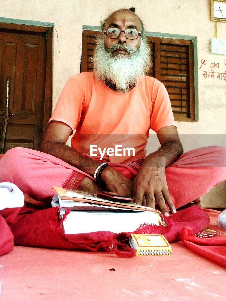 Bearded man in traditional clothing reading book at home