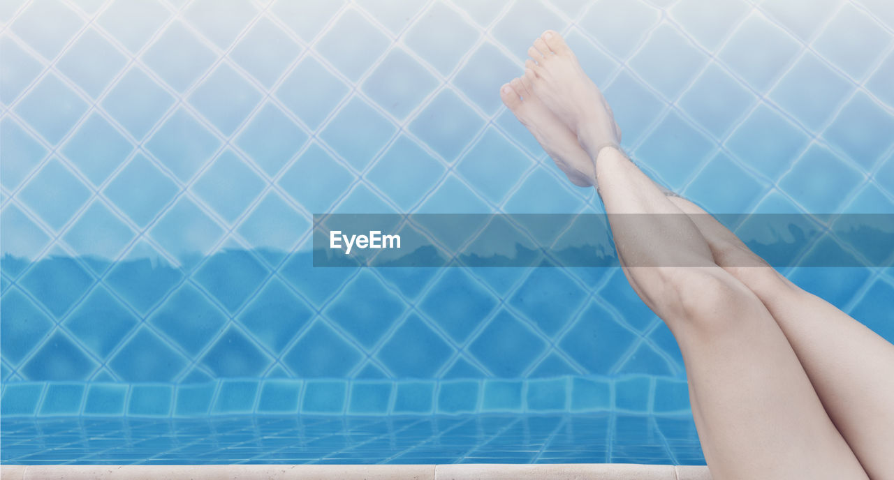 swimming pool, one person, adult, human leg, women, limb, relaxation, human limb, blue, low section, tile, young adult, barefoot, lifestyles, human foot, poolside, nature, flooring, indoors, hand, water, swimming, day, arm, female, copy space