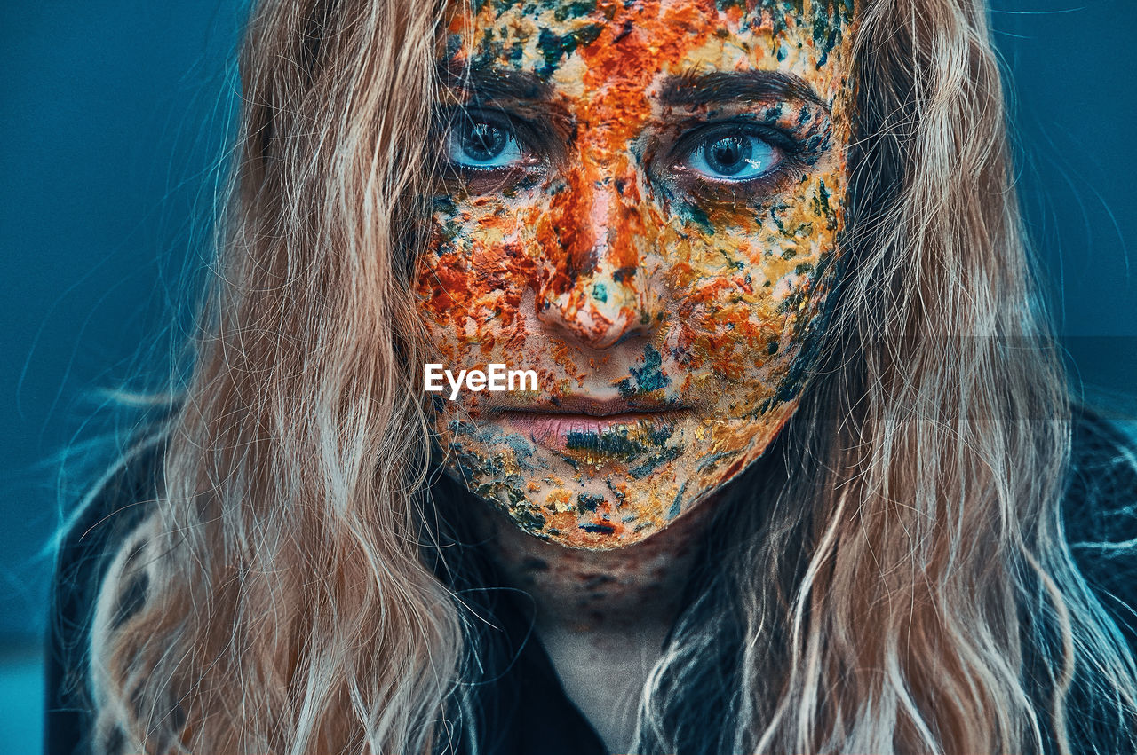 Close-up portrait of young woman with colorful face paint