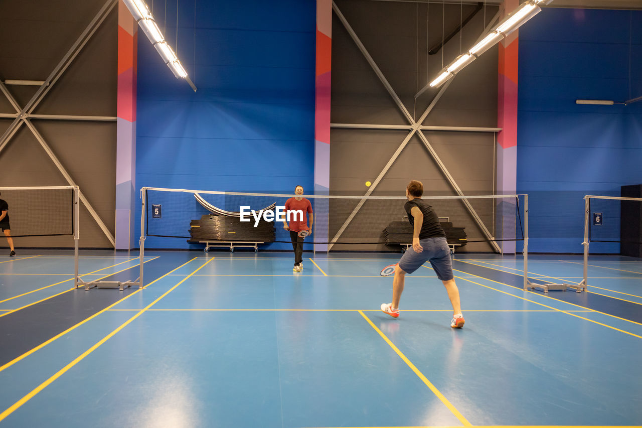 REAR VIEW OF PEOPLE PLAYING IN A BALL