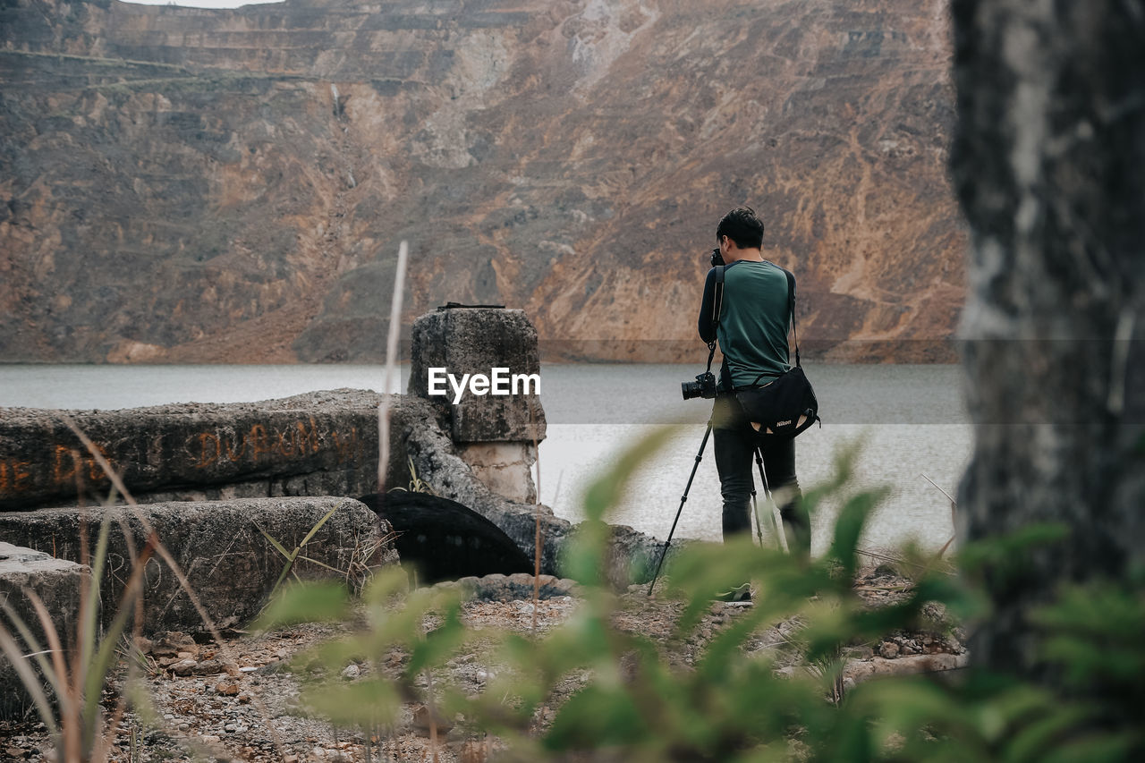 Rear view of man standing by rocks