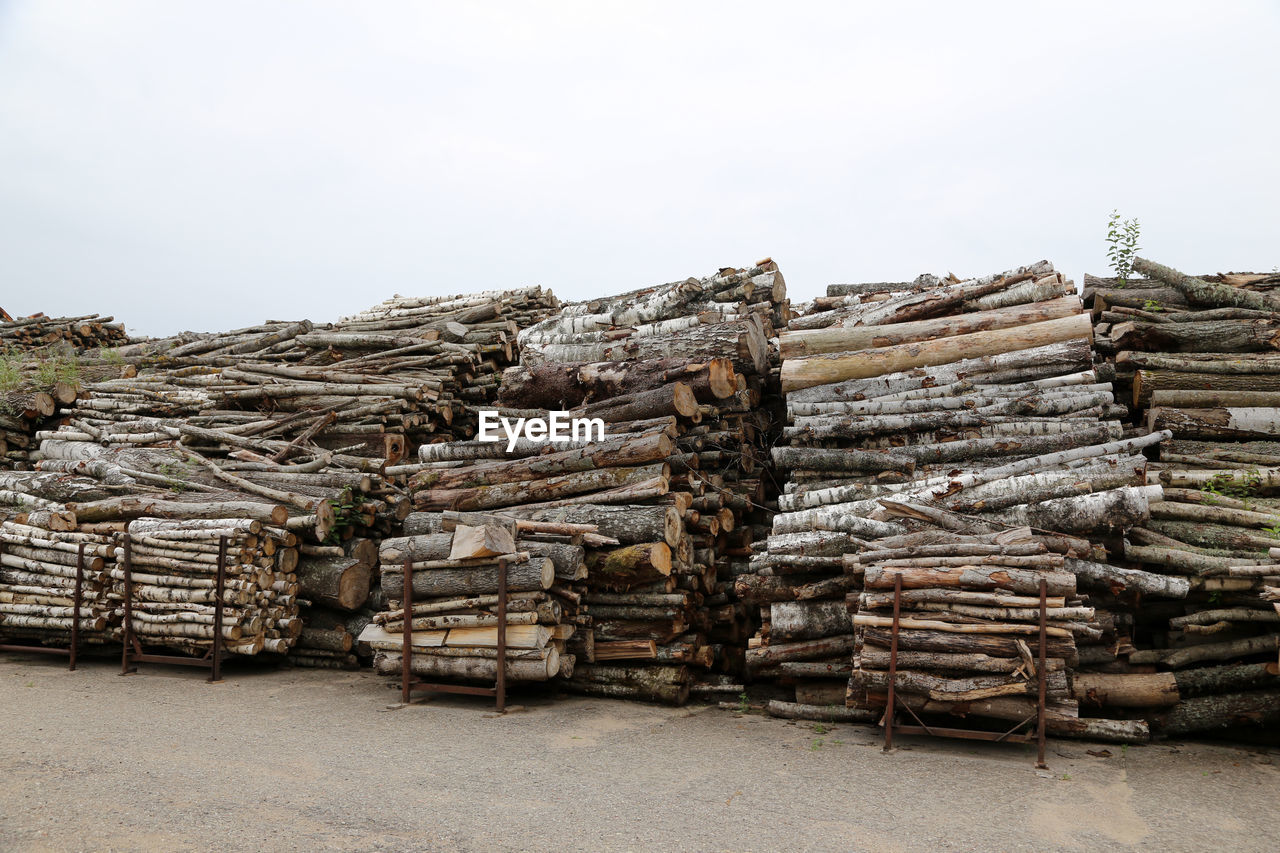 Stack of logs against sky