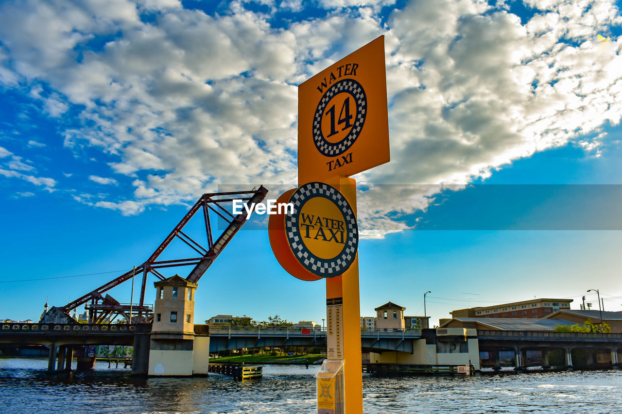 INFORMATION SIGN BY BRIDGE AGAINST SKY