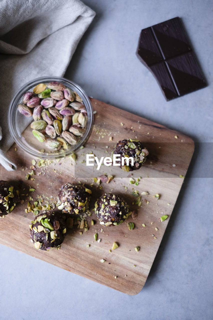 High angle view of chocolate pistachio truffle with ingredients on kitchen counter