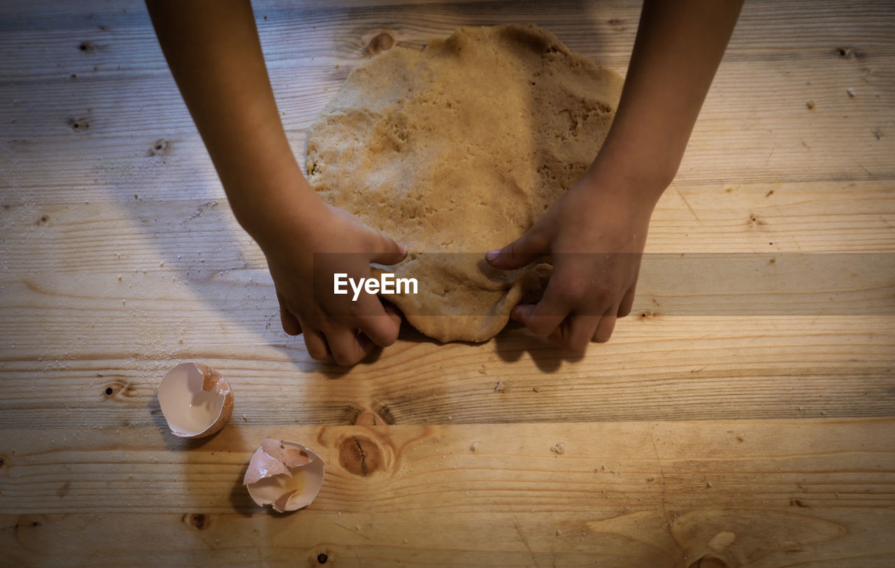 wood, hand, indoors, high angle view, table, directly above, human leg, limb, women, child, floor, childhood, hardwood floor, food, adult, food and drink, flooring, one person