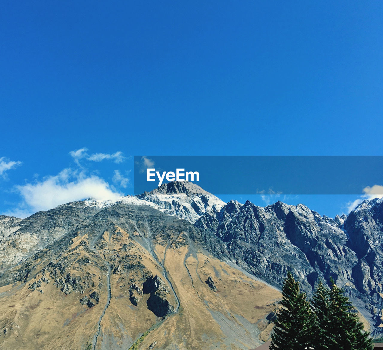 Scenic view of snowcapped mountains against blue sky