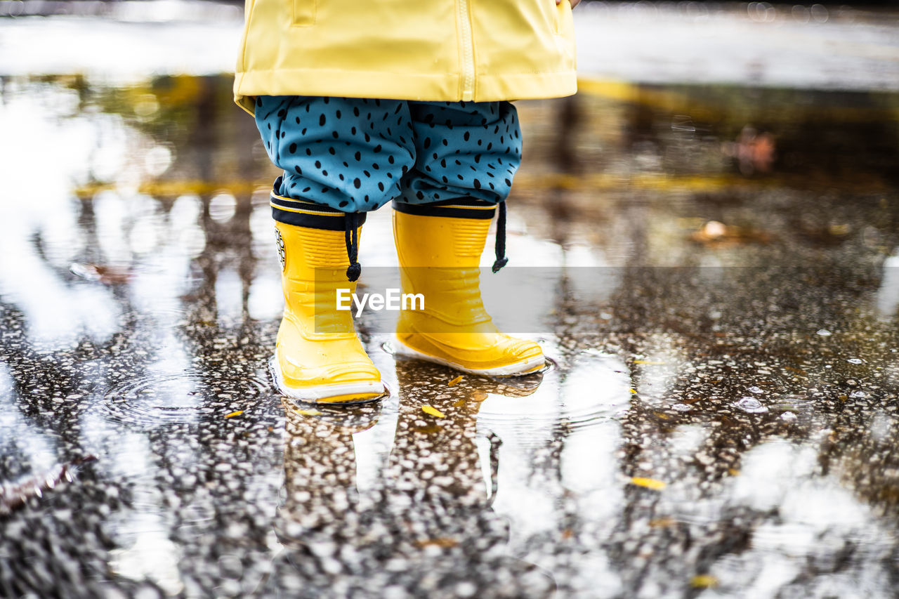 low section of woman walking on puddle