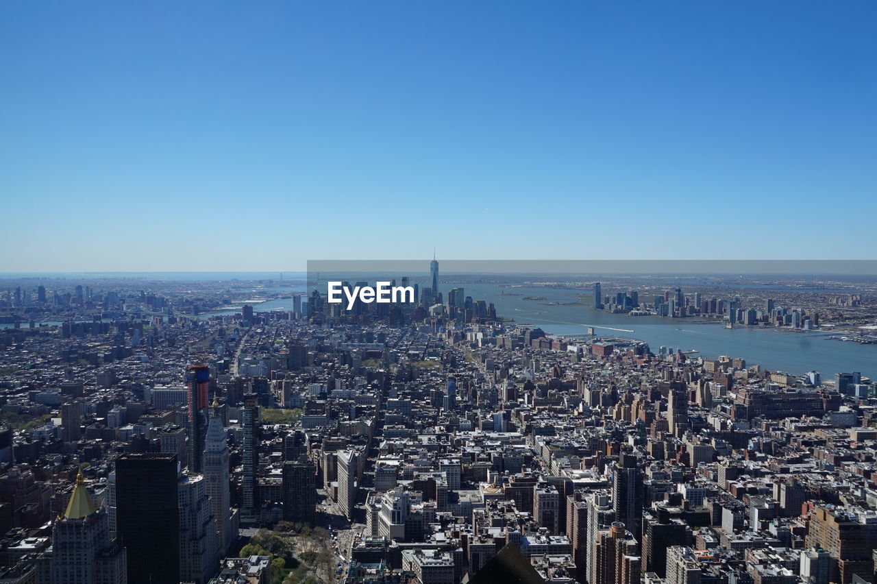 Aerial view of city against blue sky