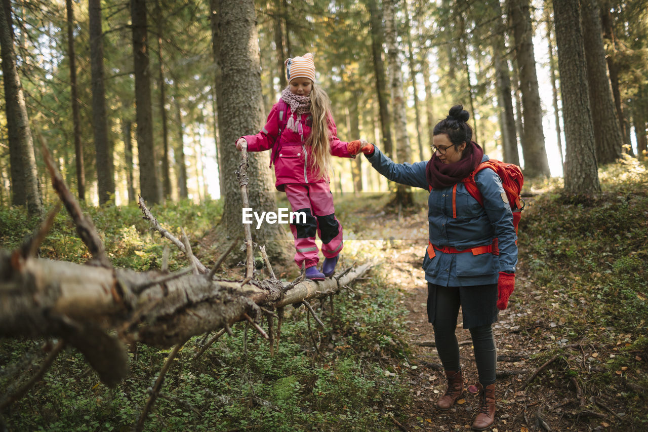 Mother with daughter walking through forest