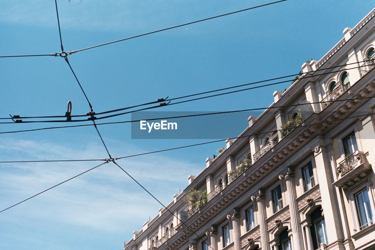 LOW ANGLE VIEW OF ELECTRICITY PYLONS AGAINST BLUE SKY