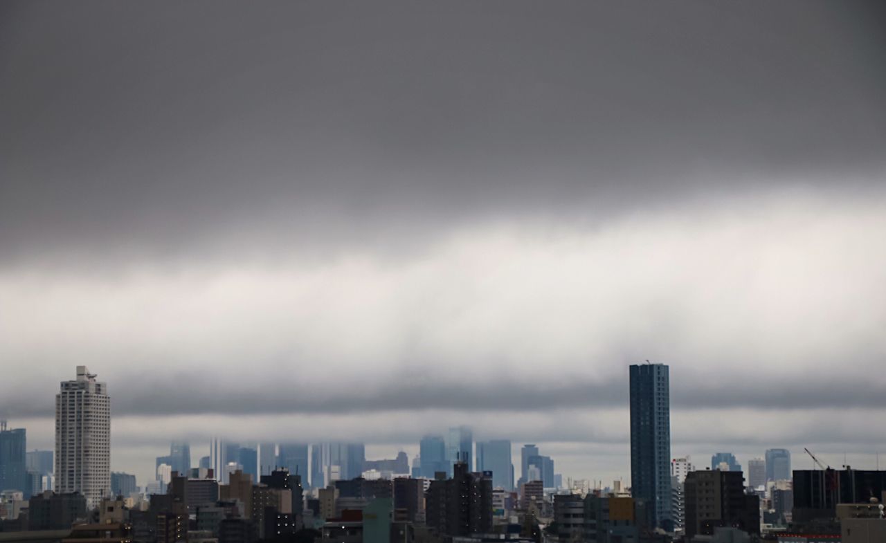 Skyscrapers in city against cloudy sky