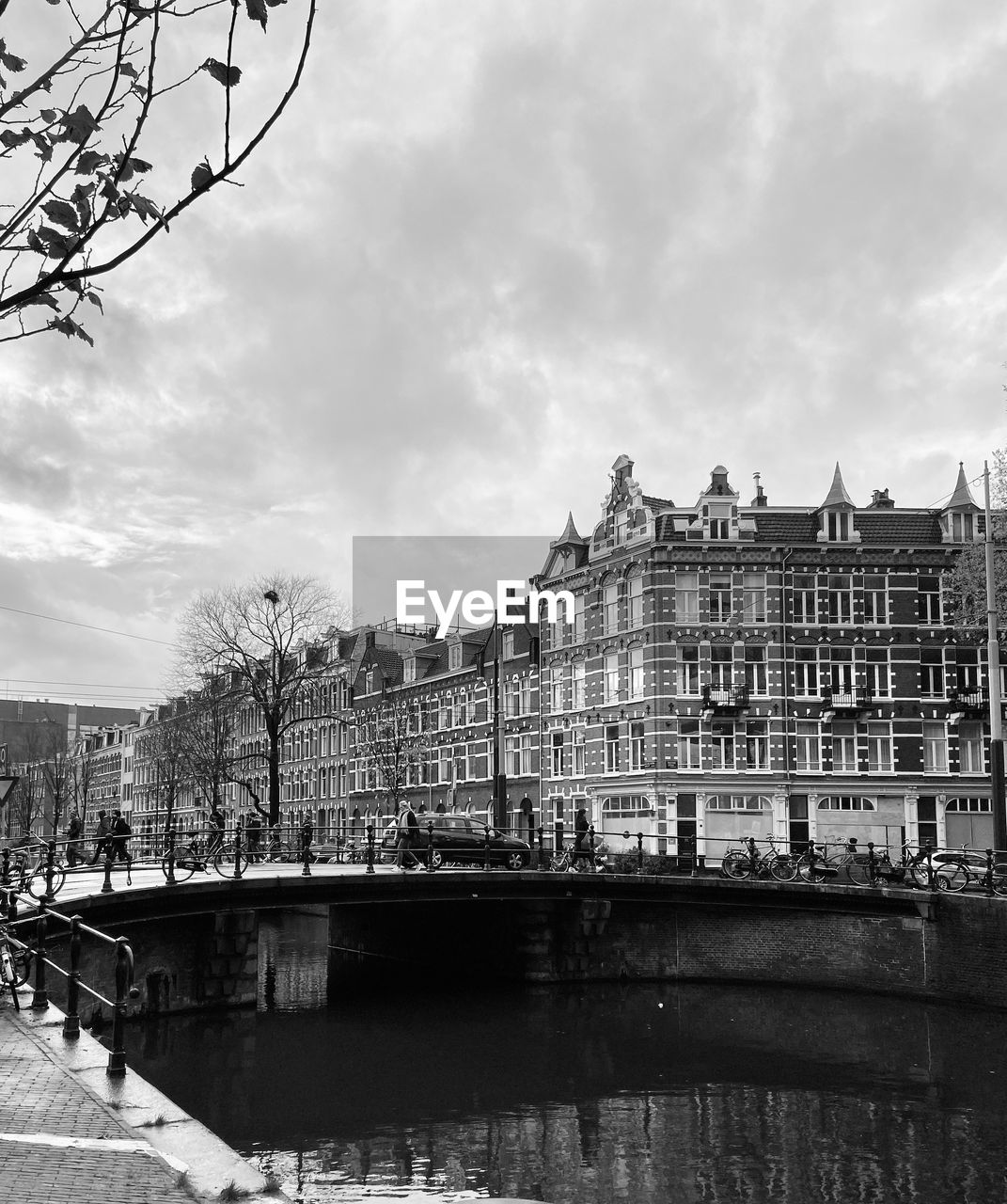 Buildings by river against sky in city