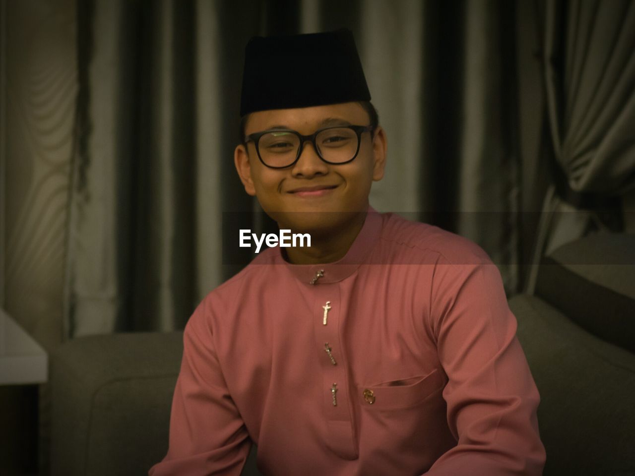 Portrait of smiling teenager boy wearing traditional clothes at home