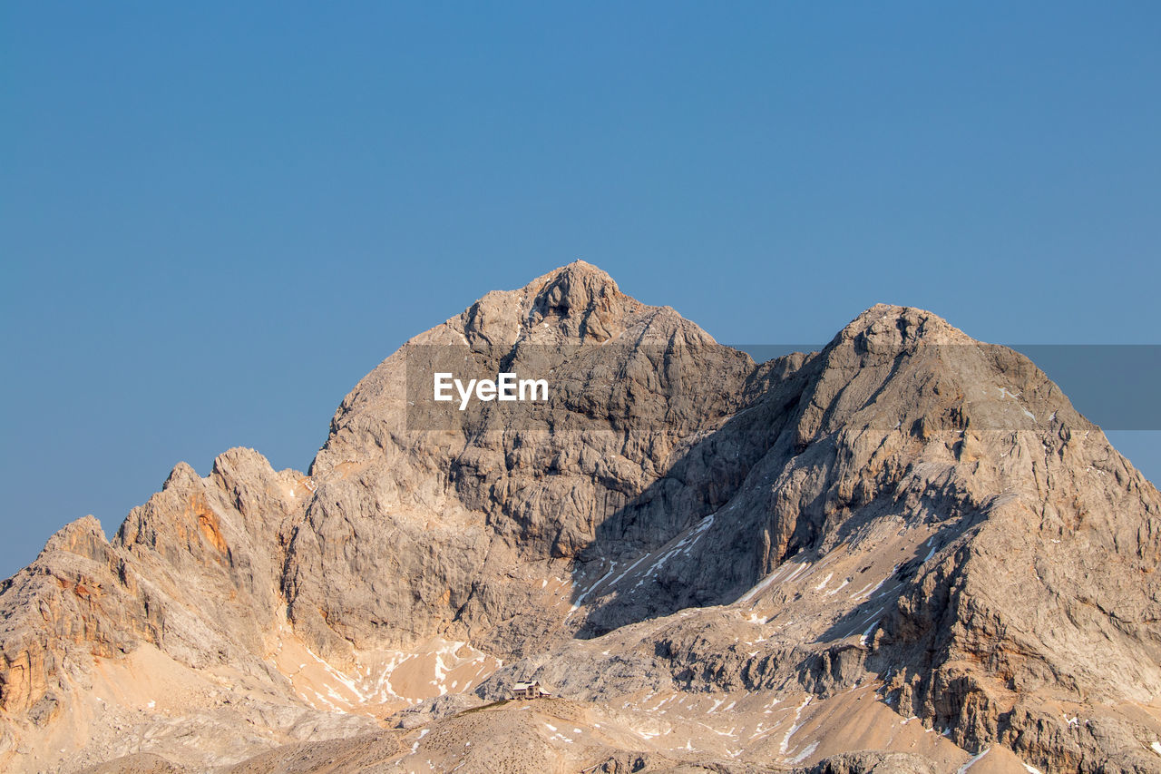 Low angle view of rock formation against clear blue sky