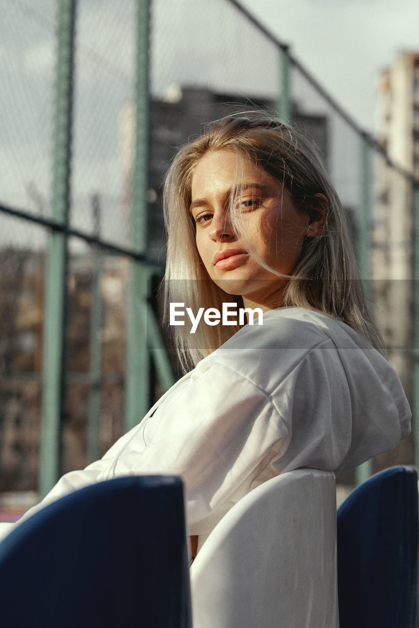 Portrait of young woman sitting outdoors