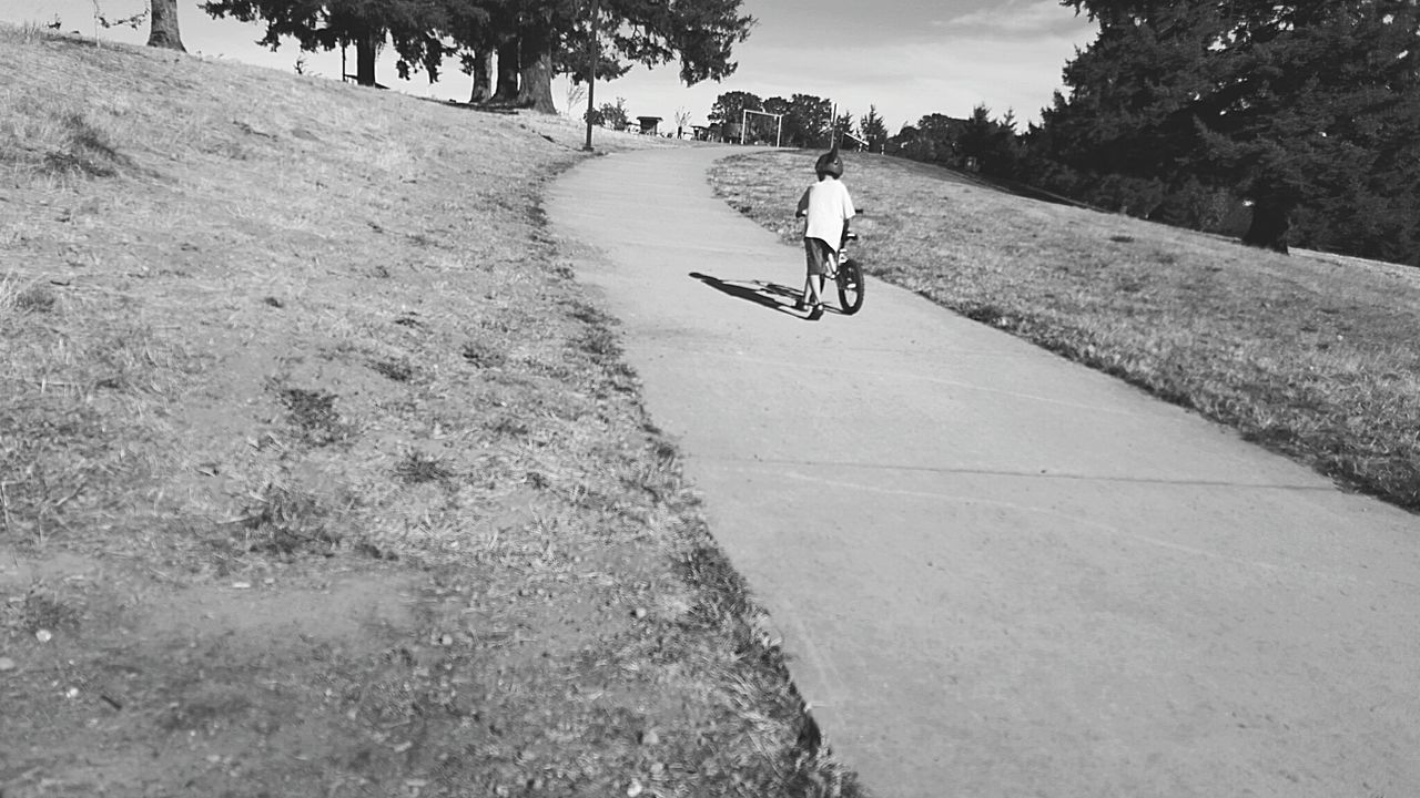 WOMAN CYCLING ON ROAD