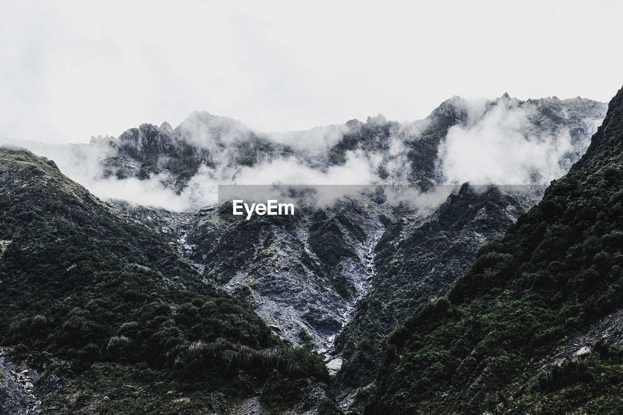 Low angle view of snowcapped mountains against sky