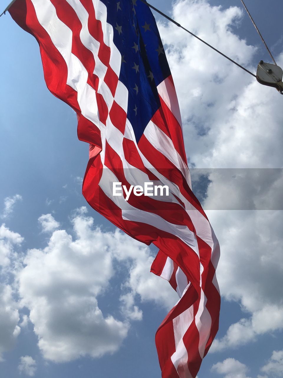 Low angle view of american flag against sky