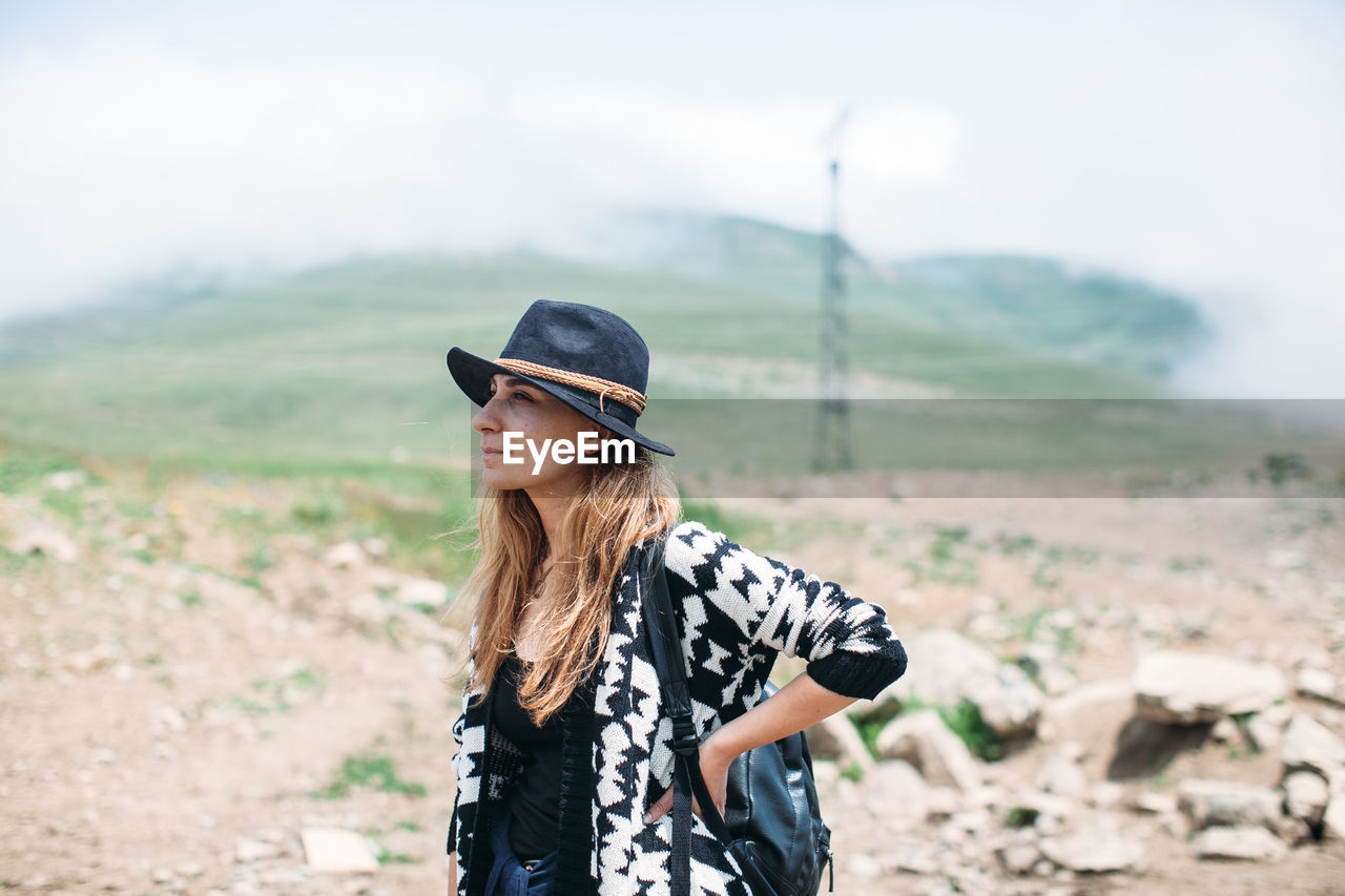 Portrait of young woman standing on field