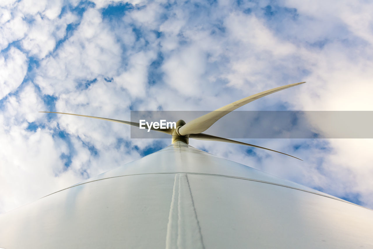 Low angle view of traditional windmill against cloudy sky