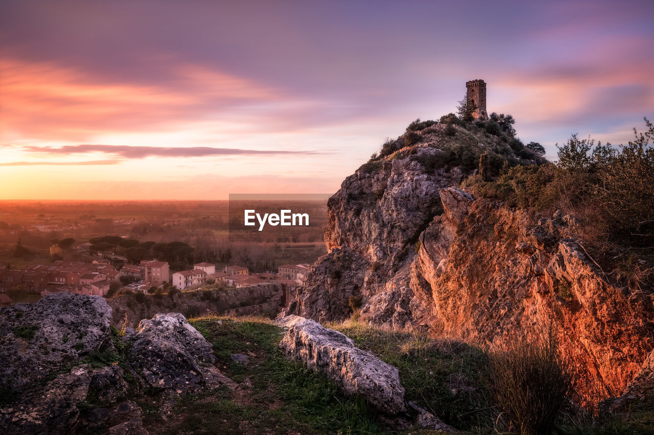 Rock formation on land against sky during sunset