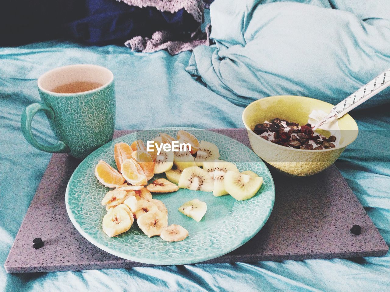 Close-up of fruit salad with coffee on bed