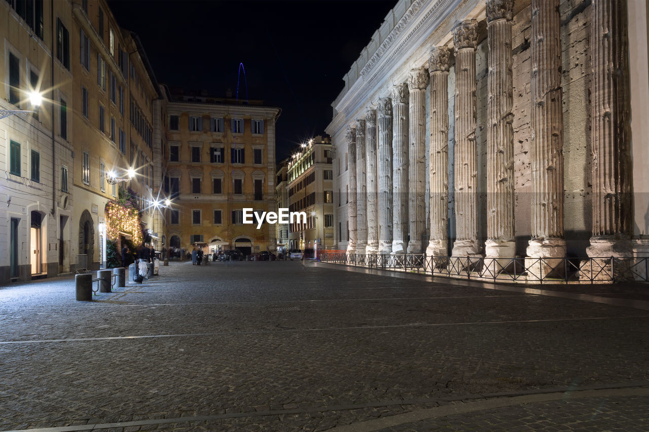 Street amidst buildings in city at night