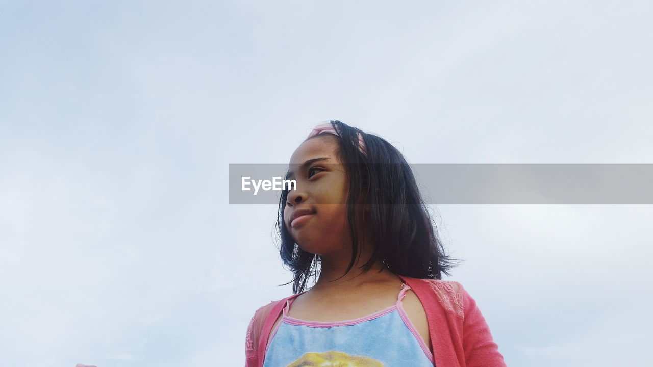 Low angle view of girl against sky