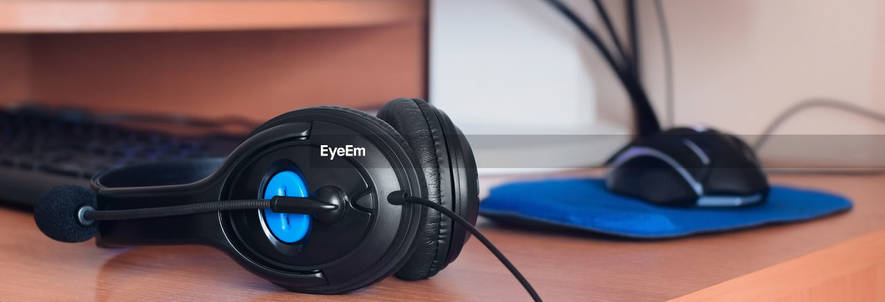 CLOSE-UP OF CAMERA ON HARDWOOD FLOOR AGAINST BLUE BACKGROUND