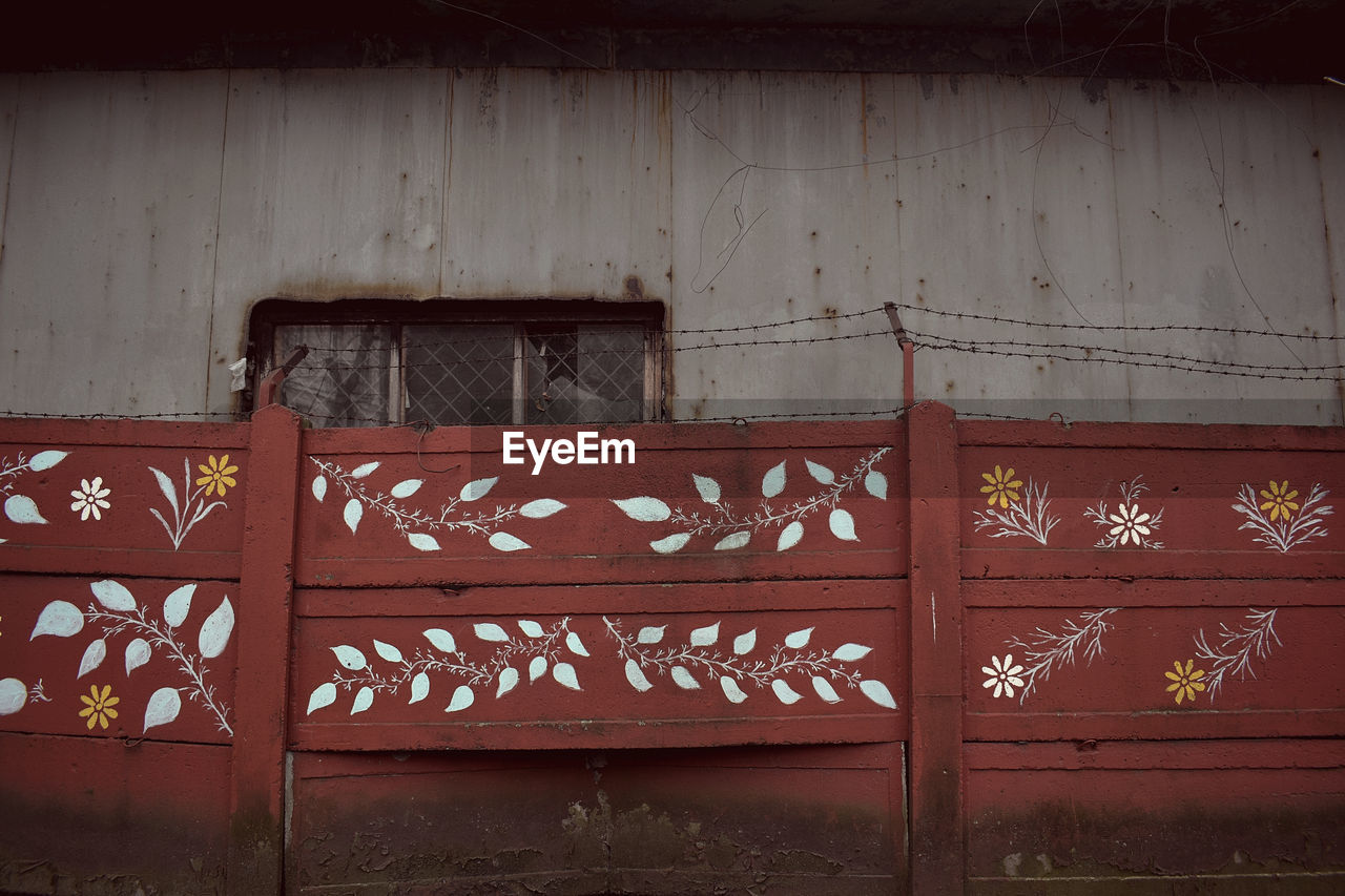 Painted wooden fence outside old building