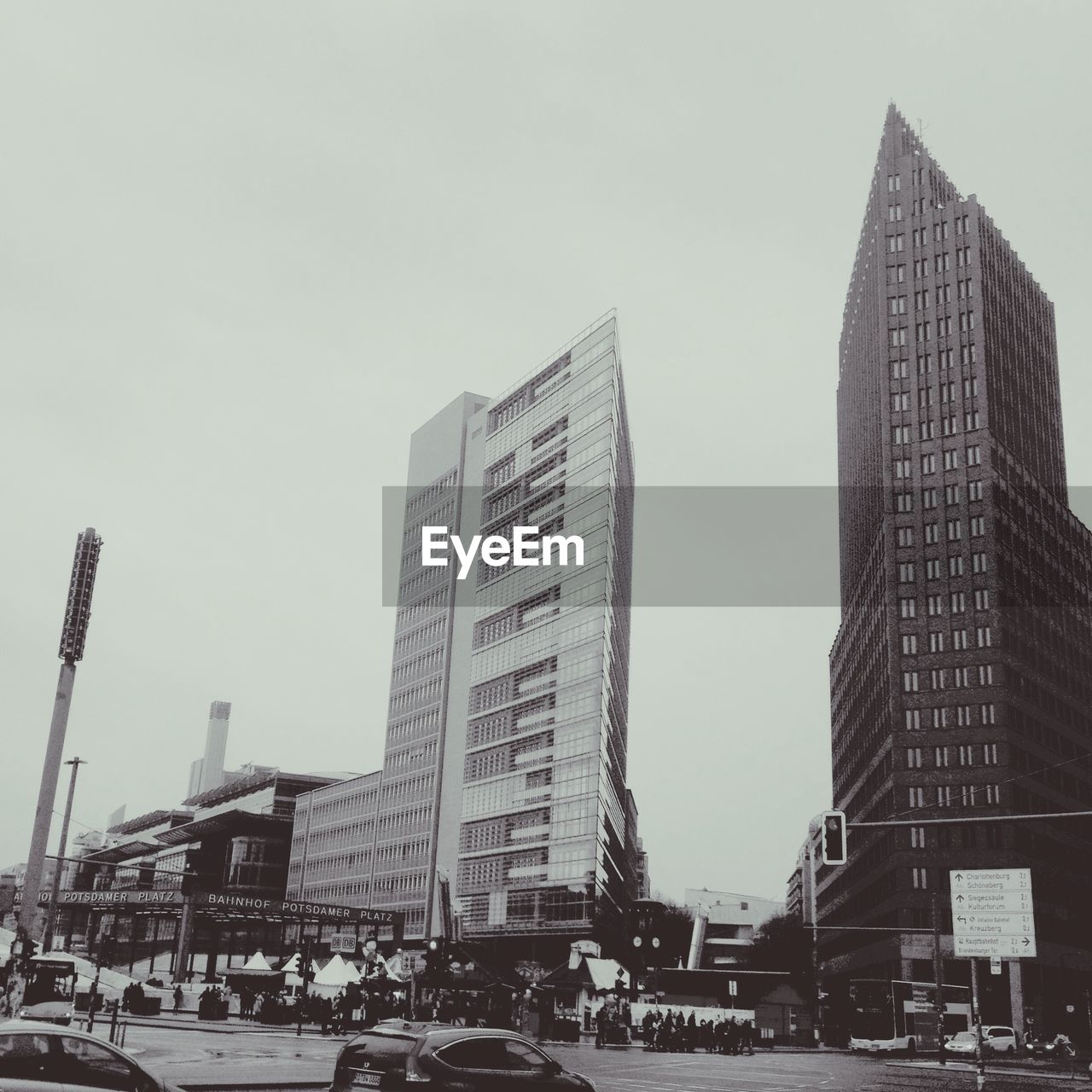 architecture, building exterior, built structure, car, land vehicle, modern, city, skyscraper, transportation, street, outdoors, day, road, sky, clear sky, large group of people, people