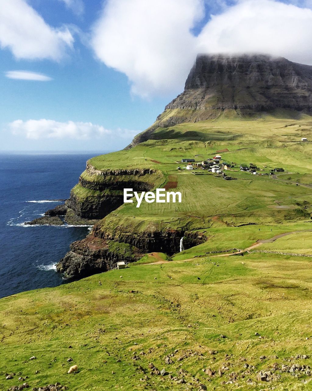 Scenic view of landscape by sea against sky