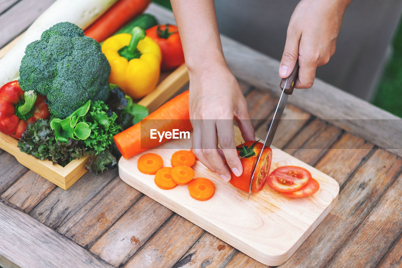 HIGH ANGLE VIEW OF MAN PREPARING FOOD ON CUTTING