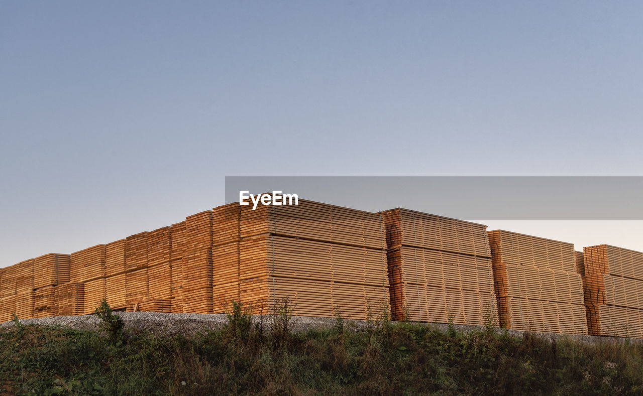 LOW ANGLE VIEW OF BUILT STRUCTURE ON FIELD AGAINST CLEAR SKY