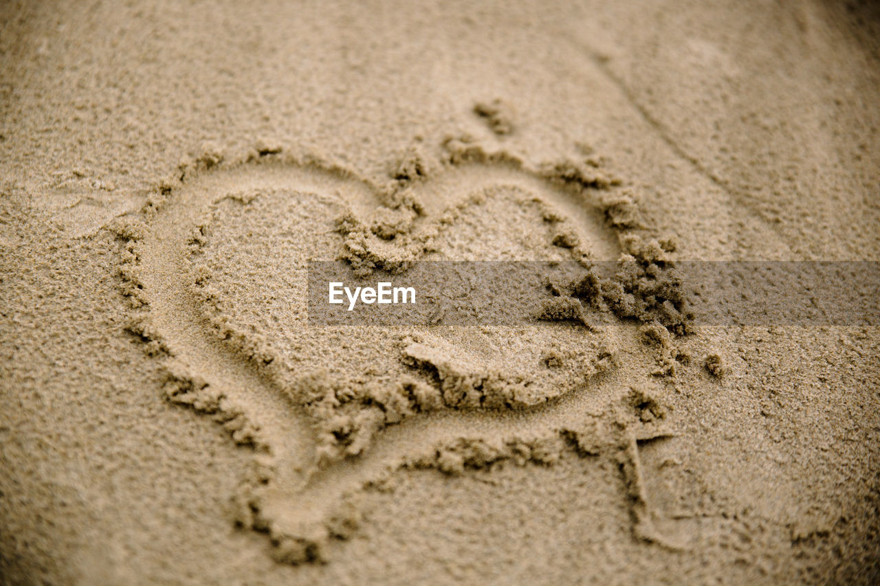 HIGH ANGLE VIEW OF FOOTPRINTS ON SAND