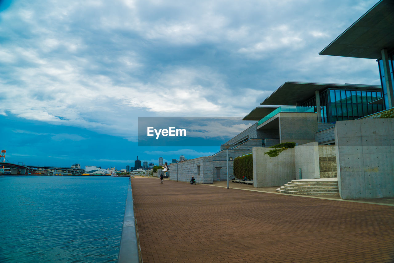 HOUSES BY SEA AND BUILDINGS AGAINST SKY