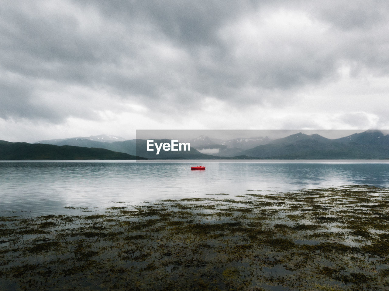 Scenic view of small boat in a fjord against sky
