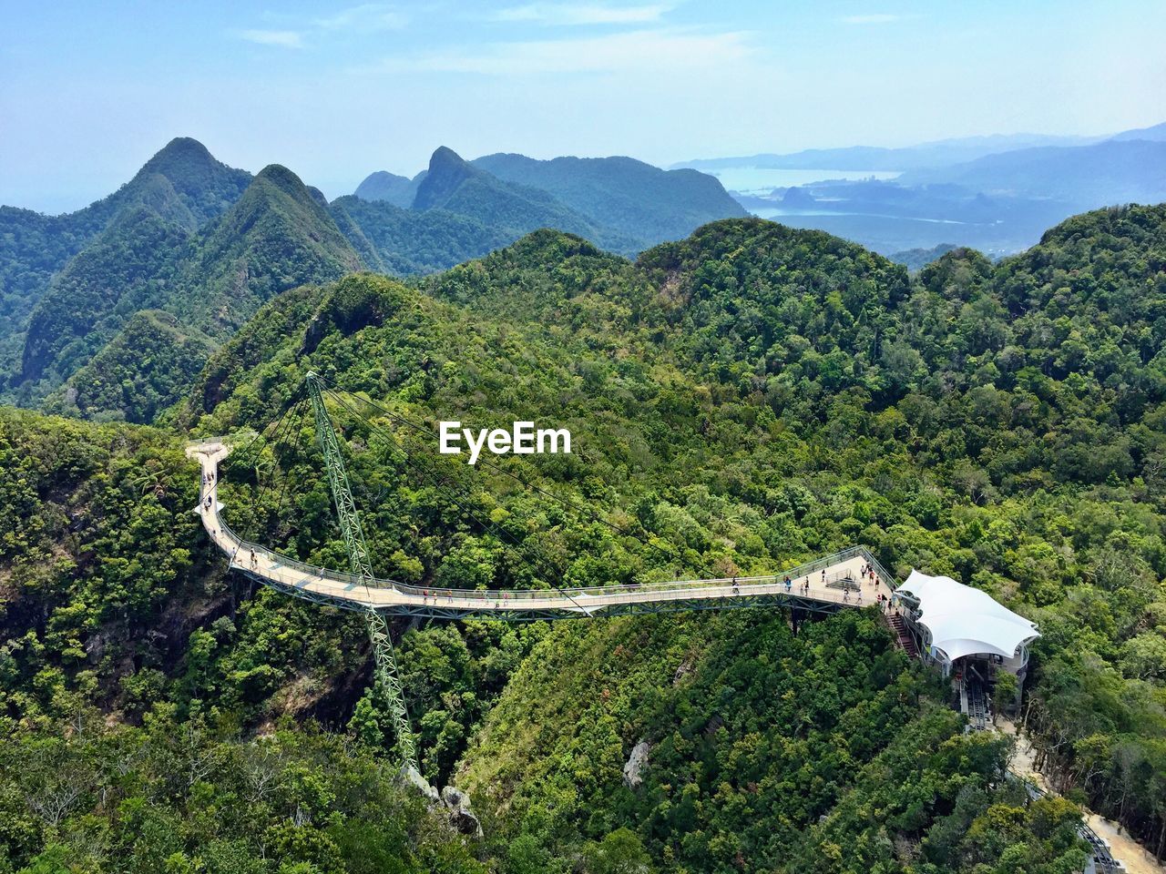 High angle view of bridge through mountains against cloudy sky