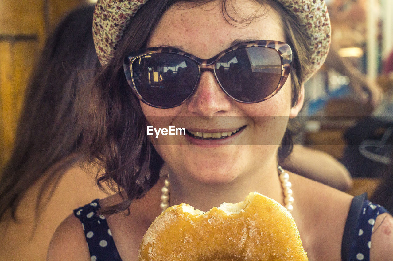 Portrait of woman in sunglasses having food at restaurant