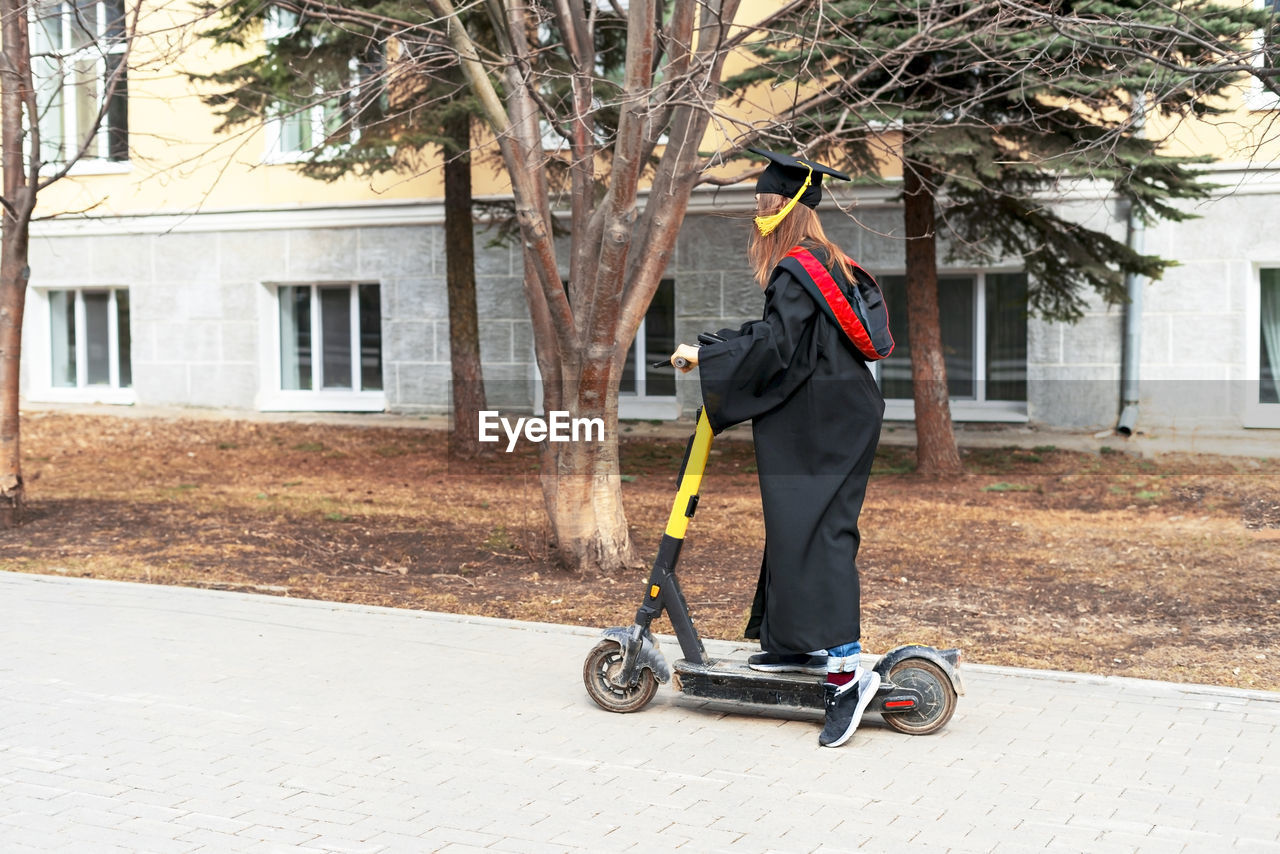 MAN RIDING BICYCLE ON STREET AGAINST BUILDINGS